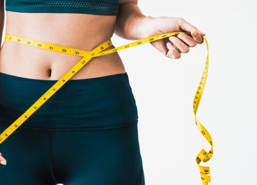 Photo of a woman measuring her waistline